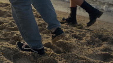夫妇脚走桑迪海滩女孩的家伙腿海洋海岸